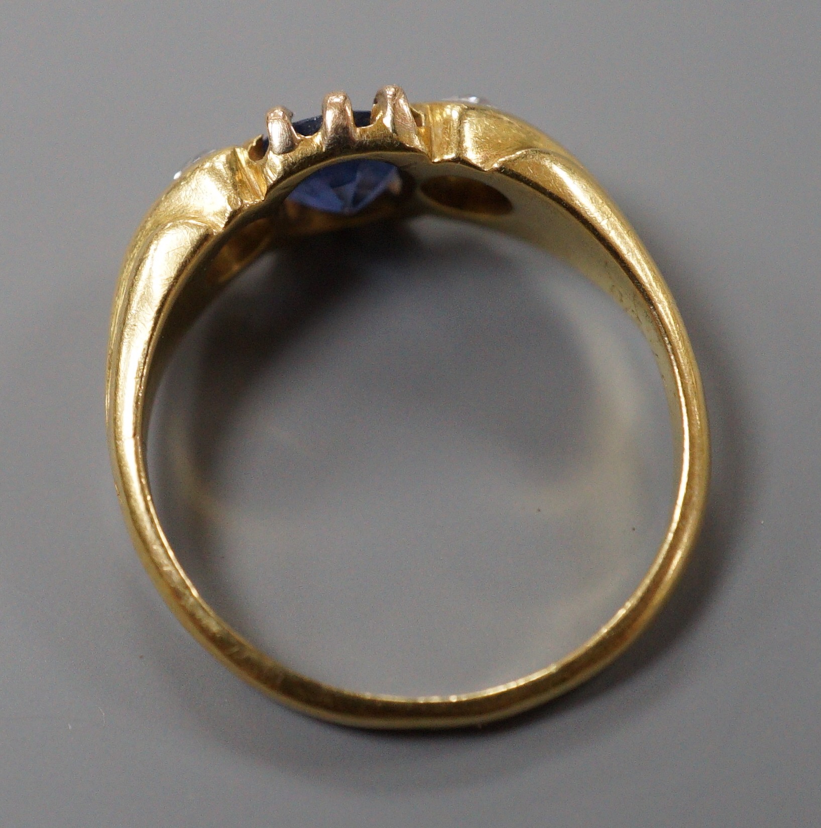 A late Victorian 18ct gold, sapphire and diamond set three stone ring, size I, gross weight 3 grams.